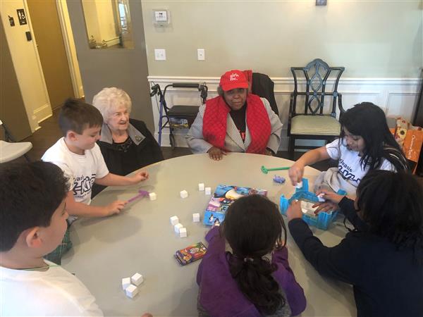 Students setting up for a round of Don't Break the Ice board game at a Senior home