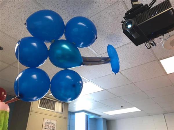 Bundle of blue balloons against an acoustic tile drop ceiling