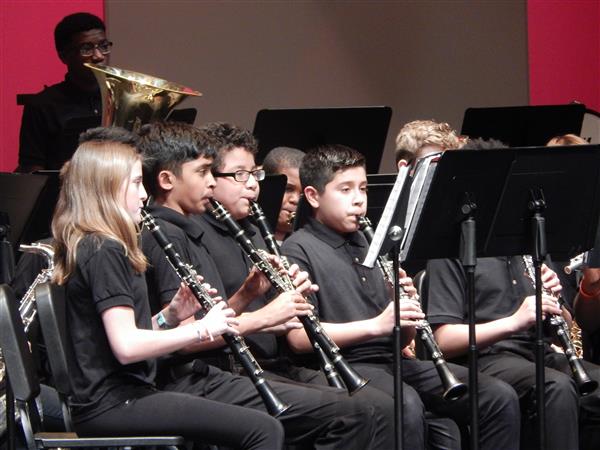 Students dressed in black performing with their clarinets