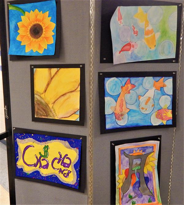 Display of student artwork with themes of koi fish and sunflowers