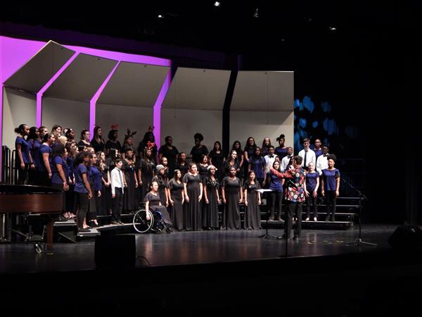 Wide shot of student chorus singing on stage
