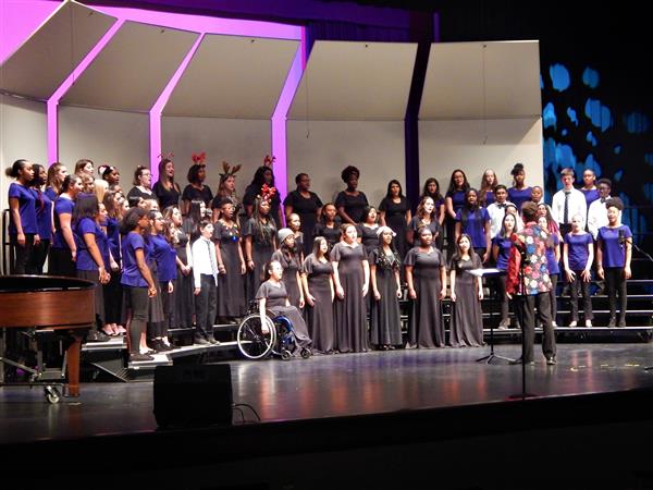 Students on stage singing during chorus performance