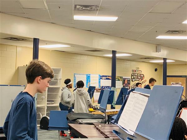 Band student standing by percussion instrument with sheet music on stand