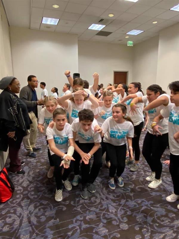 Group of students rehearsing a dance routine in classroom
