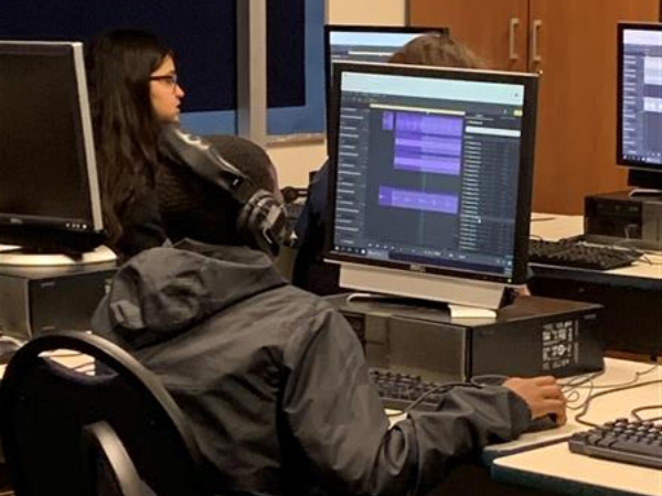 Student wearing headphones and using computer in classroom