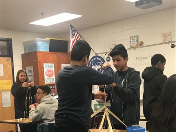 Students in classroom working together to construct structures