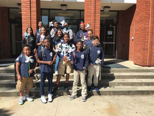 Group of students posing together and holding pinwheels