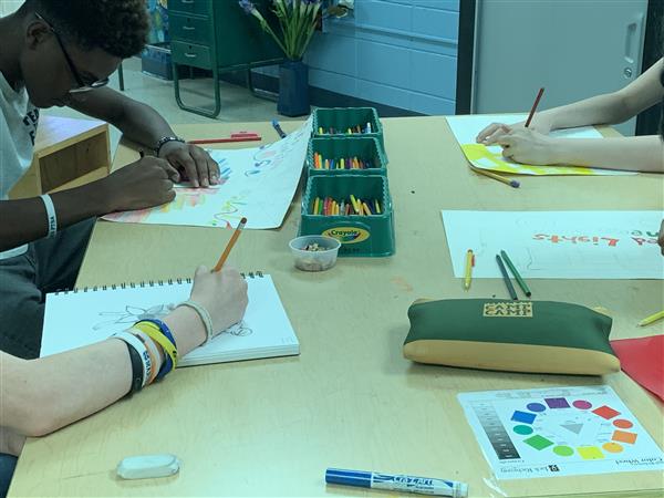 Students at table working on various art projects