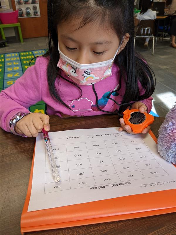 A student times herself while working on a reading exercise