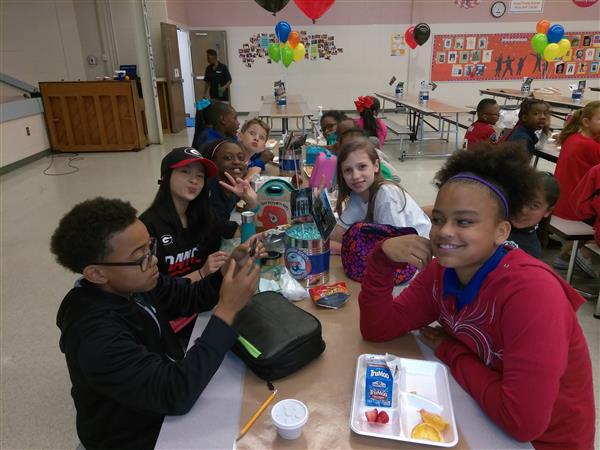 Students at their lunch table in a school cafeteria