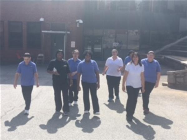 School nutrition employees walking together through a parking lot