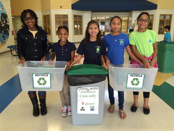Green Team club members holding clear recycling bins in a hallway