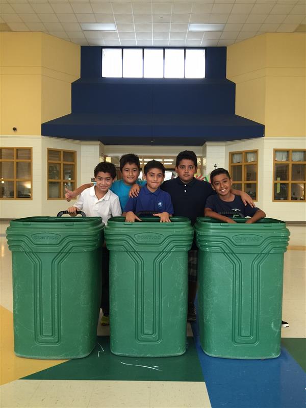 Green Team club students present large green bins ready to be filled with recyclable goods at school