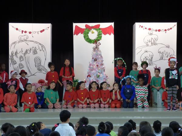 Ensemble shot of student performers in costume, performing How the Grinch Stole Christmas